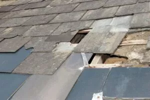 Damaged slate tiles in need of Seguin roof storm damage repair services.
