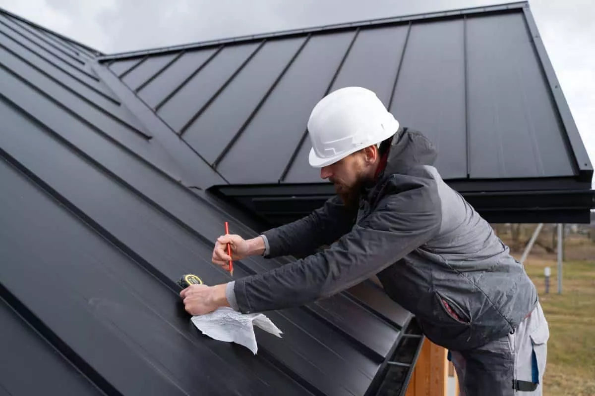 A roofer working on a black Bastrop metal roof.