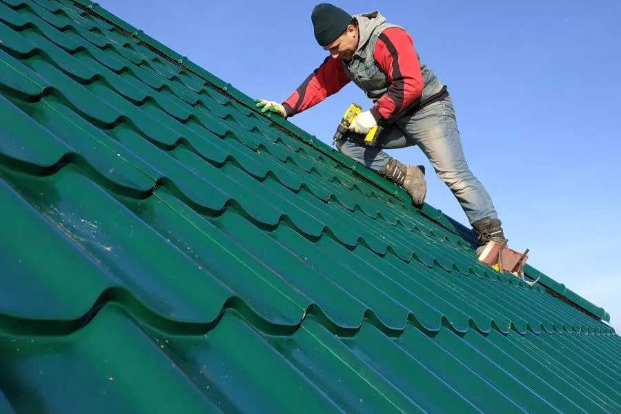Worker perform a metal roof installation in New Braunfels on a sunny day.
