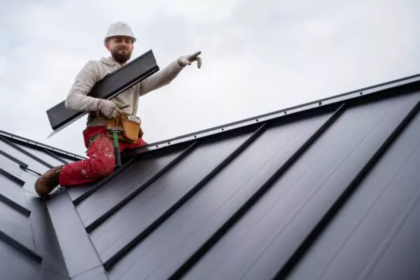 A worker installing metal roofing in Austin TX.