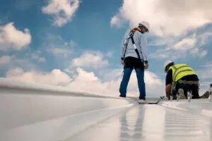 Two workers engaged in Austin roof inspecting on a sunny day.