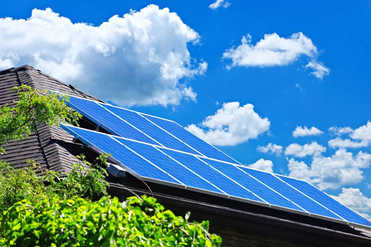 Bastrop solar roofing panels on a house under a blue sky with clouds.