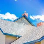 A sunlit roof in Austin with blue sky and fluffy clouds in the background.