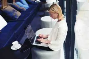 business woman working at an airport on her laptop connected to public wifi