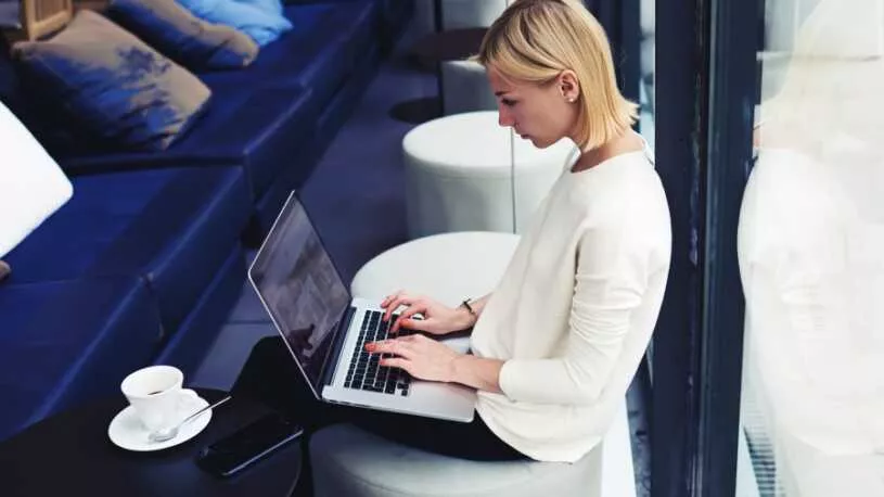 business woman working at an airport on her laptop connected to public wifi
