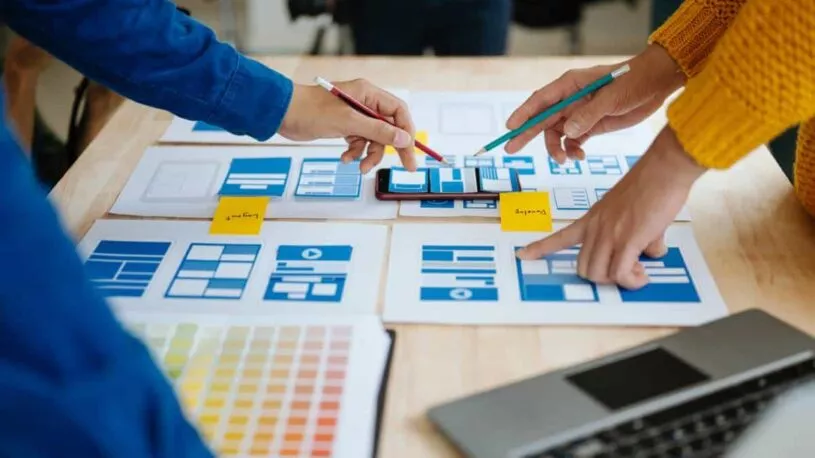 An Austin SEO team working on mobile website design layout at a desk.