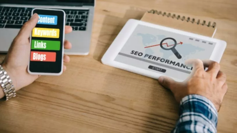 A person analyzing their San Antonio SEO strategy on multiple devices at a desk.