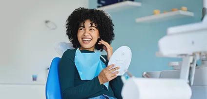 Shot of a young woman admiring her teeth after having a dental procedure done