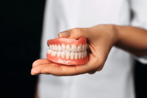 Dentures 101: Everything You Need to Know About Your Options 2 Dentist holding dentures in his hand.