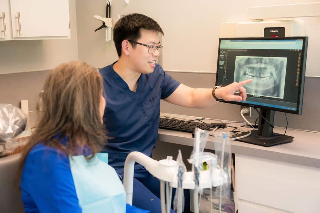 The Importance of Regular Dental Exams for Oral Health Maintenance 1 Dentist explaining x-ray result to patient.