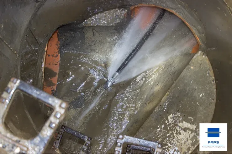 A hydro jet sprays high-pressure water to clean a dirty pipe