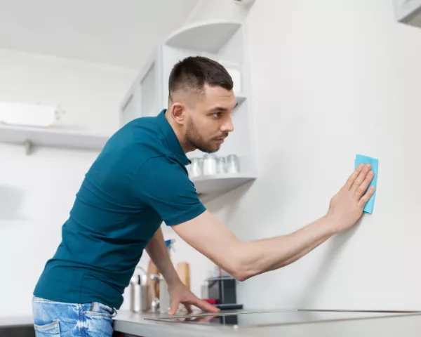 man wiping down the walls