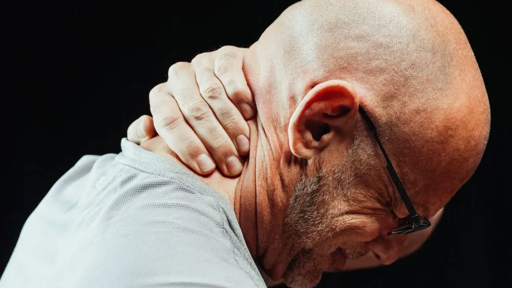Chronic Pain & Dry Eye: What Plano Patients Should Know 2 Office worker holding neck in pain, a common chronic pain complaint in Plano TX