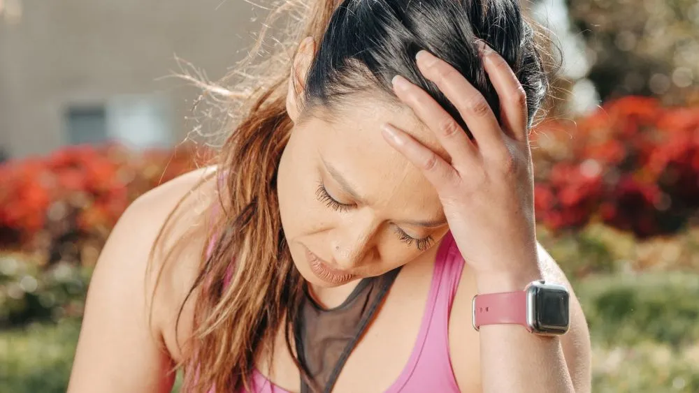 Chronic Pain in IBD & Botox for Migraines | Plano, TX 2 Woman holding her head in pain illustrating chronic migraine symptoms treated in Plano TX