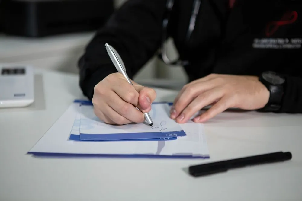 Chronic Pain in IBD & Botox for Migraines | Plano, TX 4 Patient filling out consultation paperwork at a pain management clinic near Plano TX