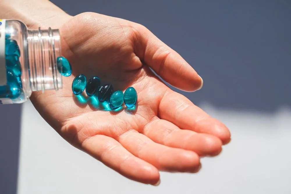 Melatonin & Botox for Chronic Migraines in Grand Prairie, TX 1 Melatonin supplement capsules on a nightstand beside a glass of water