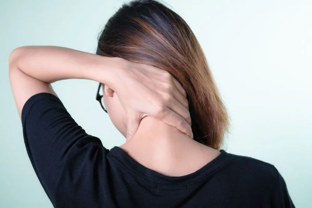 Melatonin for Chronic Pain & Migraines in Tyler, TX 1 Woman holding her neck experiencing chronic head and neck pain at home