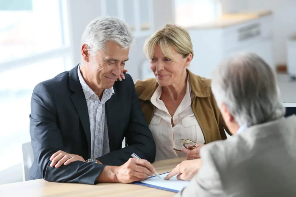 Older couple signing on a paper - Sprint Funding