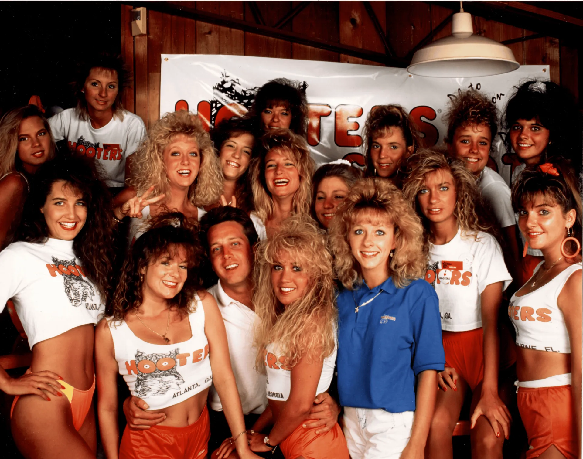 Steve D. deGuzman team at Hooters promotional event, showcasing vibrant 1980s fashion, energetic atmosphere, and team spirit. Perfect for SEO on team photos, 1980s fashion, industry events, and promotional campaigns.