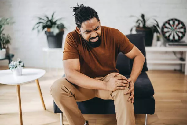 Man with knee pain sitting in a chair.