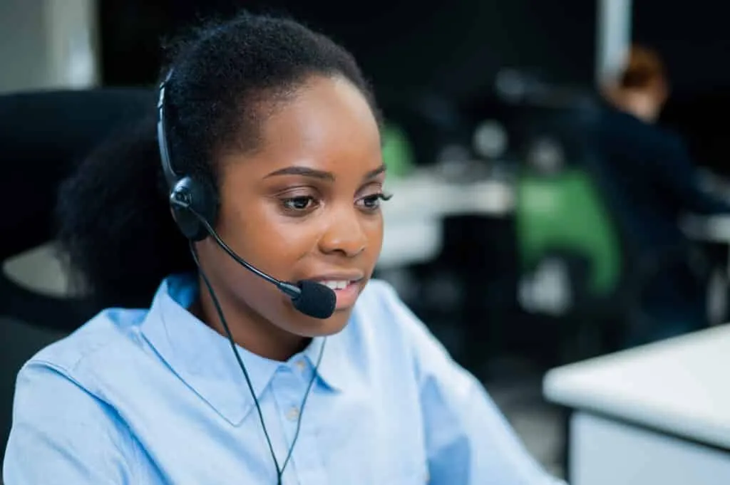 African young woman talking to a client on a headset.