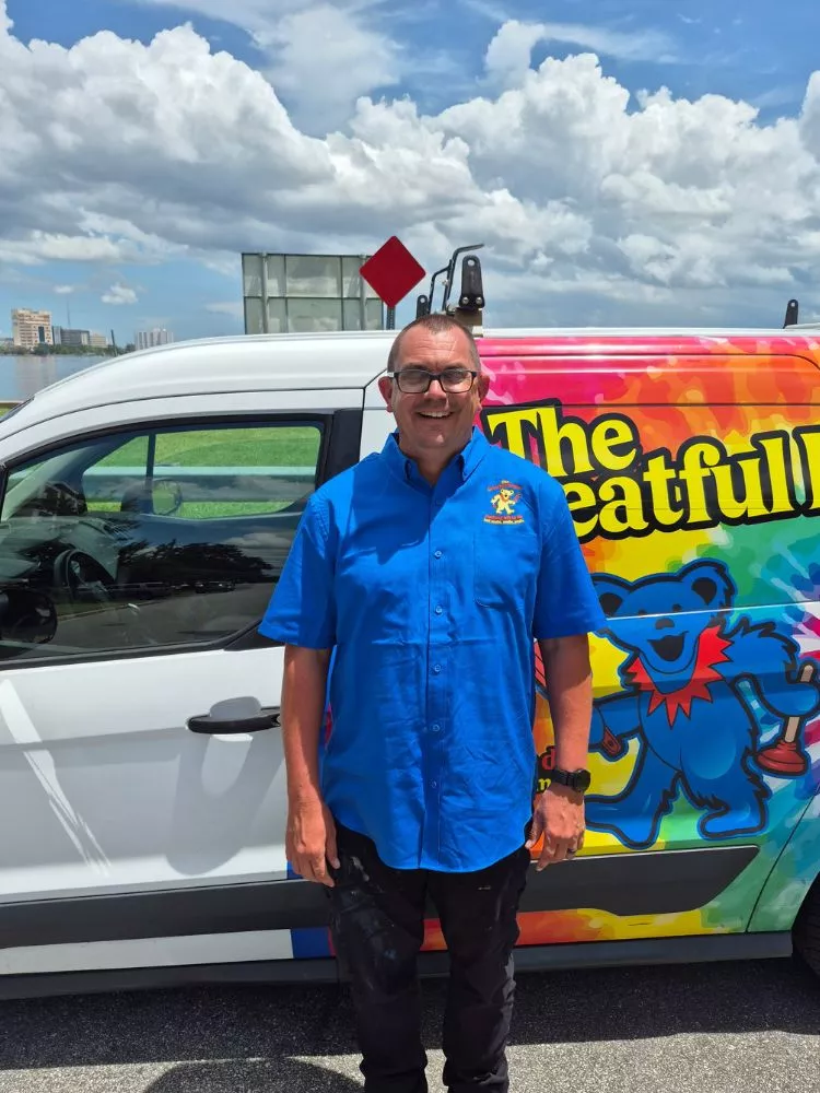 Danny, professional plumber standing next to The Greatful Plumber service van with St. Johns River in background, Jacksonville Florida