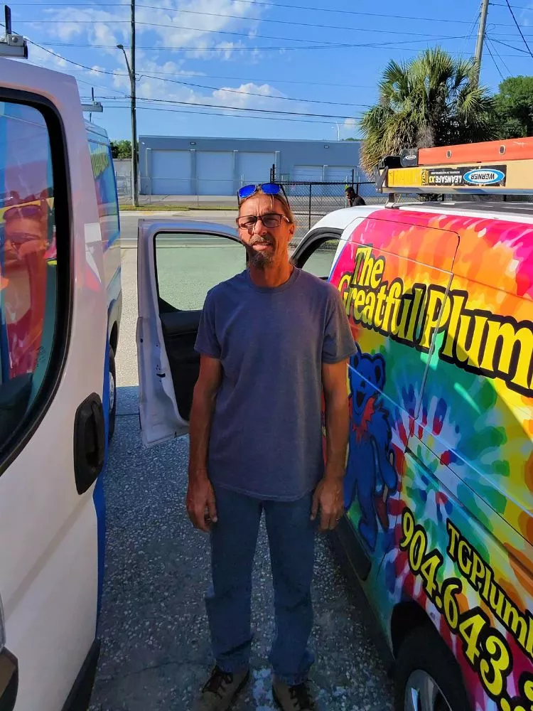 Pat, experienced Jacksonville plumber with 25+ years experience, standing next to The Greatful Plumber service van in Jacksonville Florida