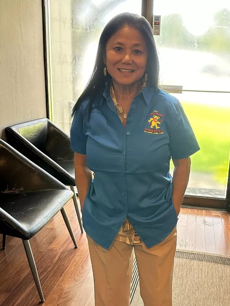 Thuy, office manager at The Greatful Plumber, wearing company uniform in Jacksonville office