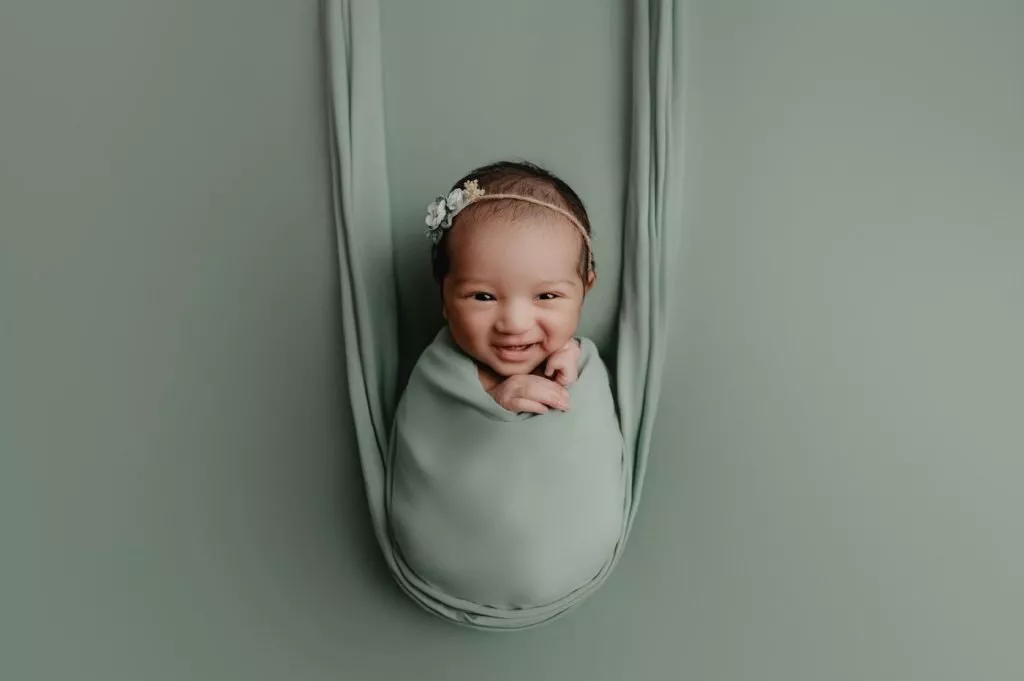 Newborn Photography Vancouver - baby girl smiling on sage backdrop