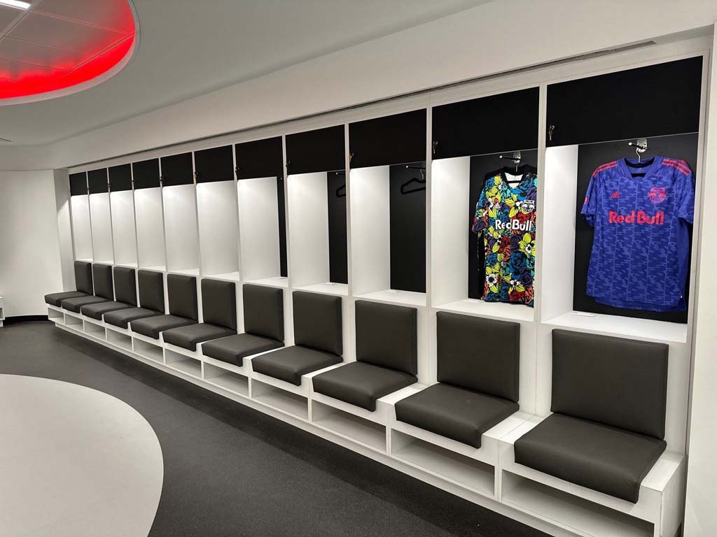 Modern locker room with custom RedBull jersey display and comfortable seating.
