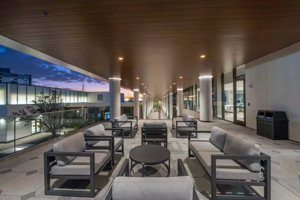 Luxurious outdoor lounge area with modern furniture and ambient lighting at twilight.