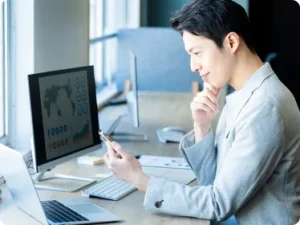 スマホを見て微笑むスーツの男性