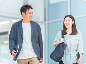 ビジネス街を微笑みながら歩く男女