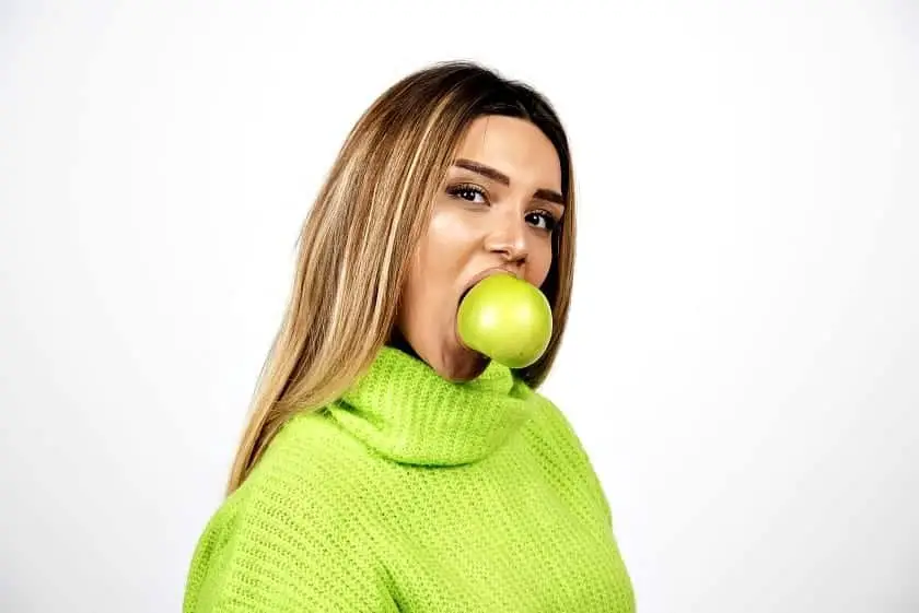 Young woman in green t-shirt eating an apple. High quality photo 4 Quick Ways To Lose Belly Fat For Women
