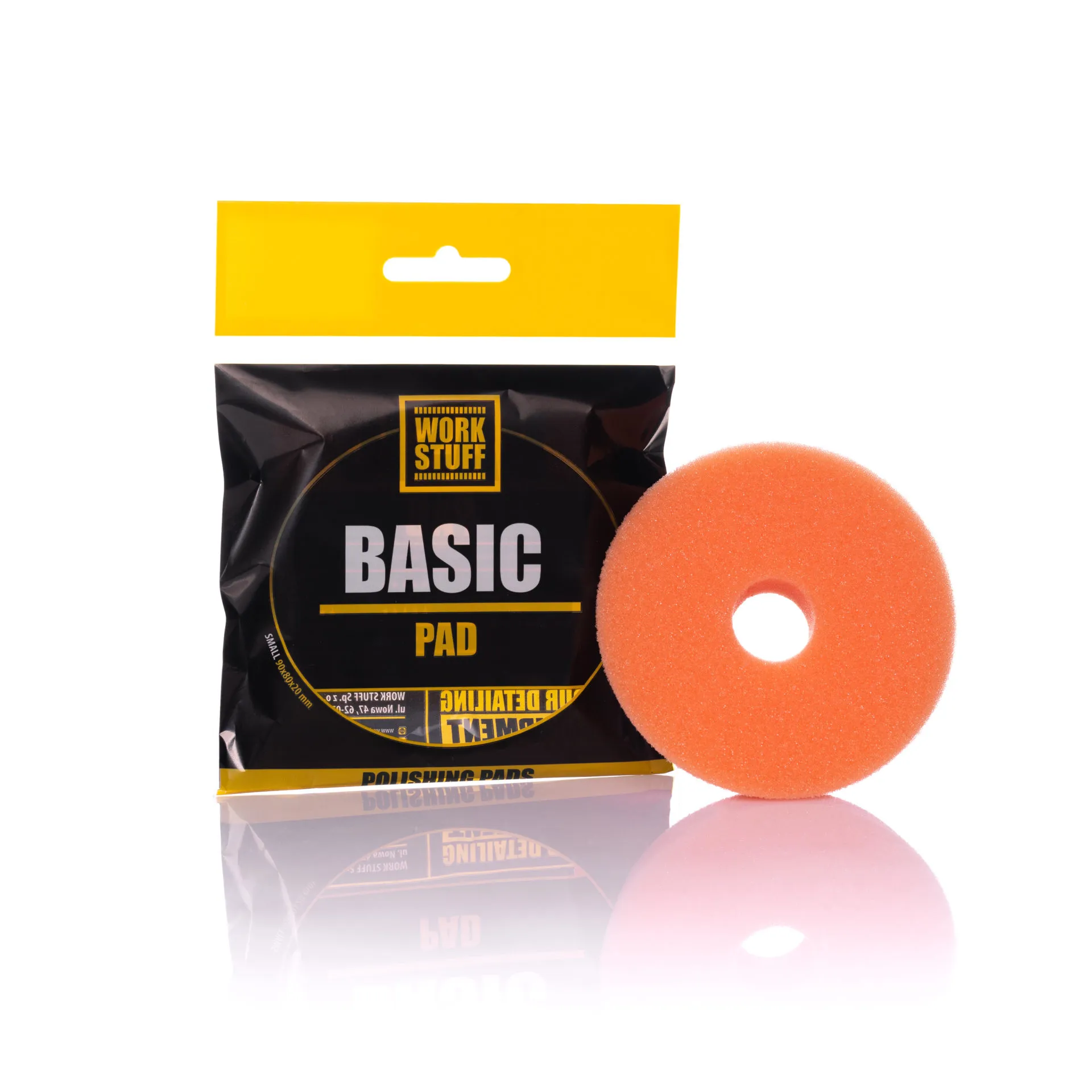 Pomarańczowy, okrągły, piankowy pad polerski z otworem na środku obok czarno-żółtego opakowania Work Stuff Basic Pad.