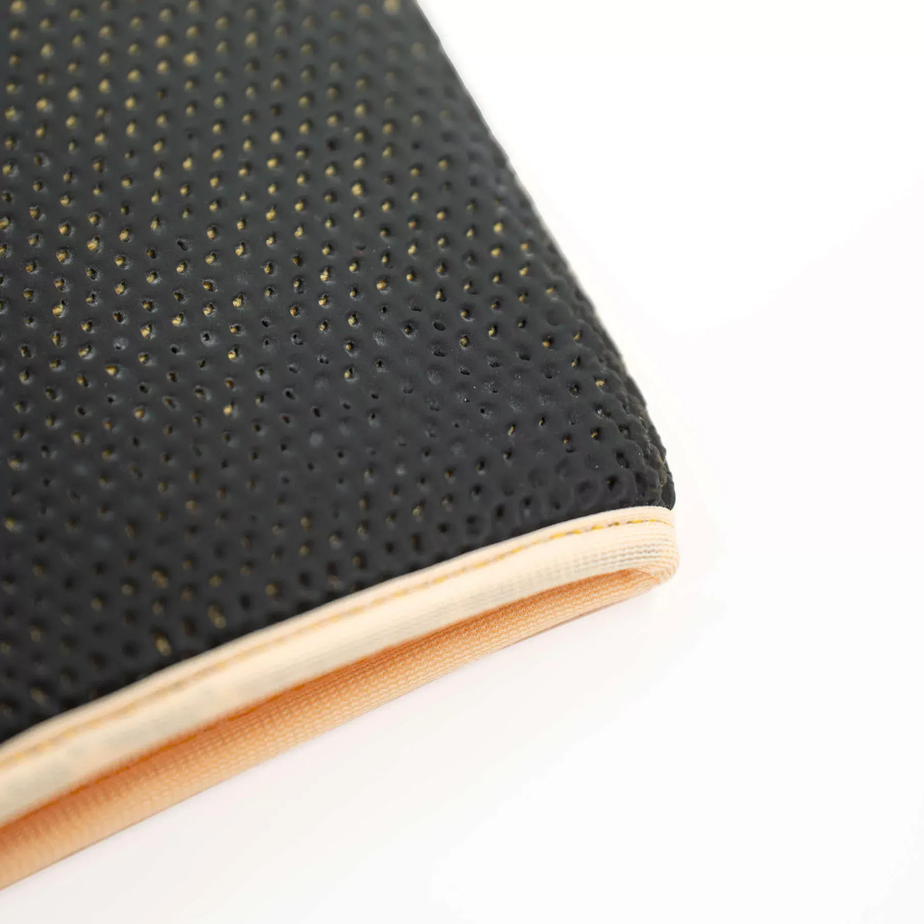 Black textured professional drying towel with small holes, beige border, shown close-up against a white background.