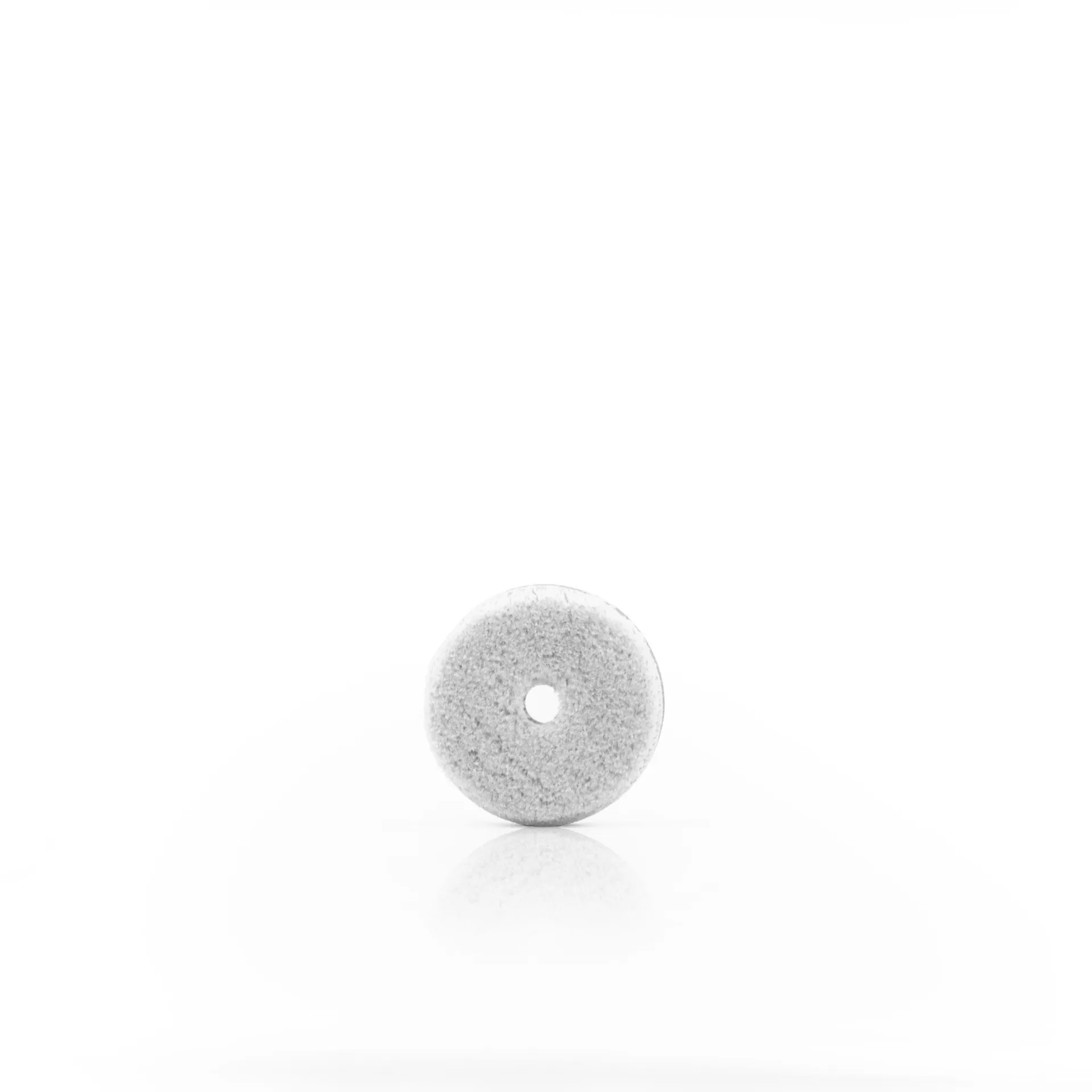 Round white stone-like object with a small central hole, soft texture, on plain white background reminiscent of a drying towel.