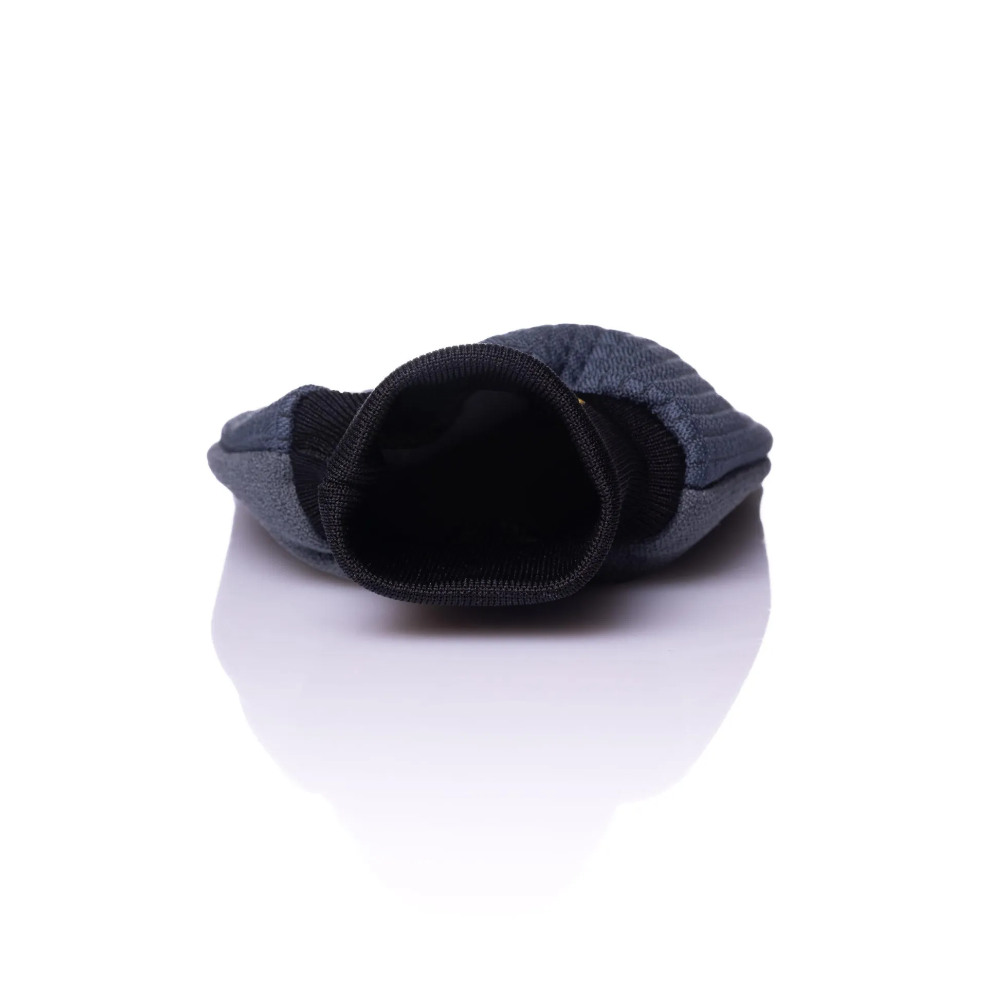 Gray microfiber car detailing towel with black elastic opening, lying flat on a white reflective surface, open end visible.