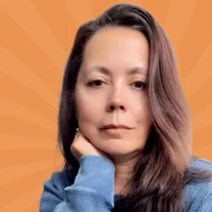 Woman with long brown hair resting her chin on her hand, wearing a blue sweater, against an orange background with sunburst pattern.