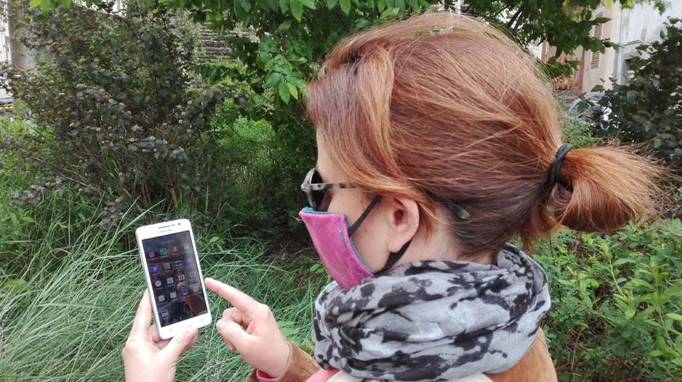 Femme masquée regardant une application