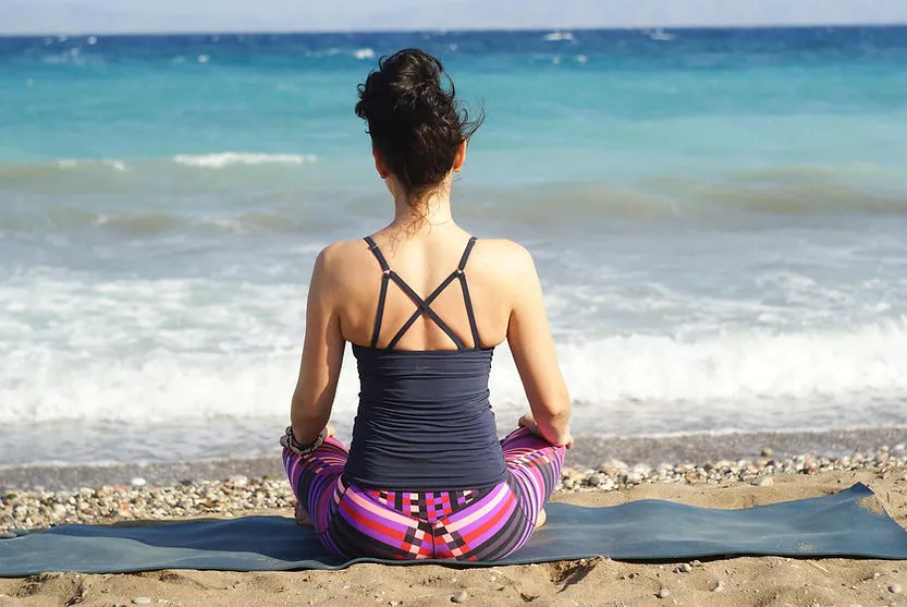 woman doing yoga on beach