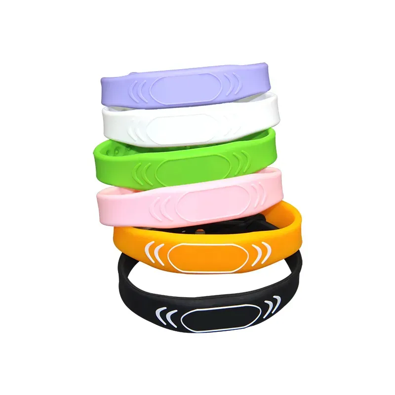 Una colección de pulseras RFID para festivales en una variedad de colores como el morado, blanco, verde, rosa, naranja, y negro. Cada pulsera cuenta con un elegante elemento de diseño rectangular en su superficie.