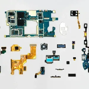 拆卸的智能手机组件, 比如电路板, 相机, and various connectors that illustrate the principles and applications covered in "Understanding RFID Technology Principles and Application," 铺在白色表面上.