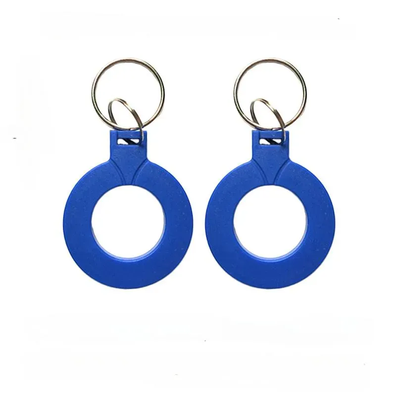 Dos unidades del llavero nfc, que cuentan con etiquetas redondas de plástico azul con anillos de metal, están dispuestos uno al lado del otro para proporcionar un acceso conveniente a través de su funcionalidad NFC.