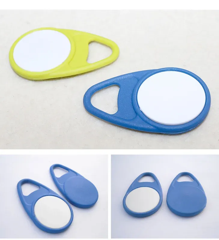 The image displays three "RFID Key Fob Tag (1)" genstande i forskellige farver: gul, blå med et hvidt center, og solid blå. Disse nøgle -fobs er sandsynligvis beregnet til identifikation eller elektroniske applikationer.
