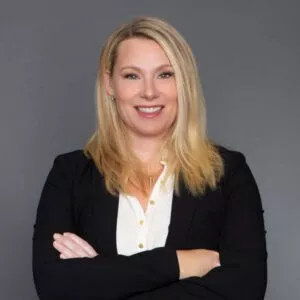 Headshot of Dr. Kathryn B. Freidl in professional wear with a grey background.