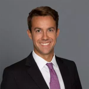 Headshot of Dr. Jason Miles in professional wear with a grey background.