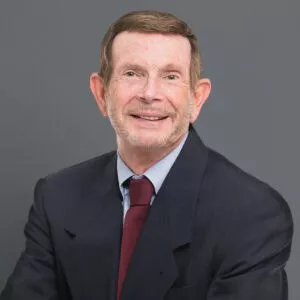Headshot of Dr. Jerry Maida in professional wear with a grey background.