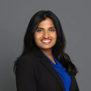Headshot of Dr. Francis in professional wear with a grey background.