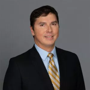 Headshot of Dr. Kenzo Koike in professional wear with a grey background.